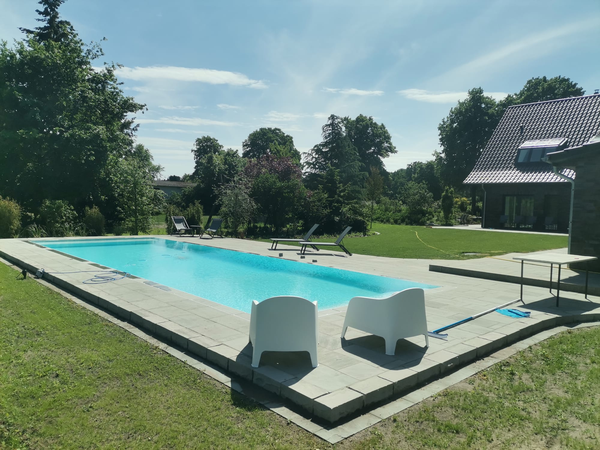 Gepflasterte Terrasse mit Einfassung und angrenzender Rasenfläche